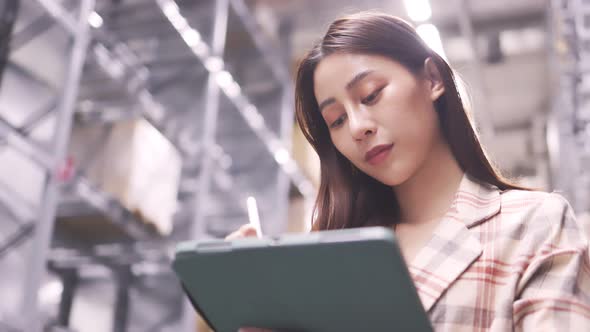 Portrait of smiling asian manager worker woman standing and order details on tablet