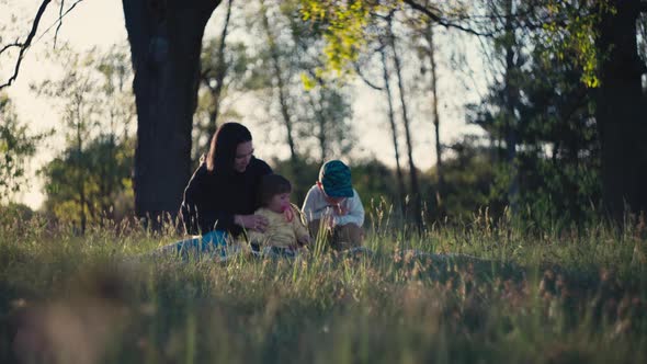 Mother Plays with Children in Nature