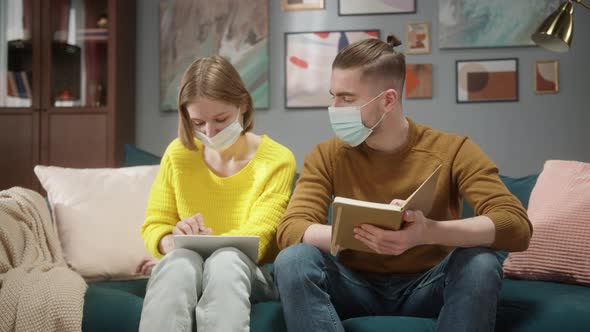 Loving Students Couple Wearing Medical Masks Indoors at Home Preparing for Exams Woman alt