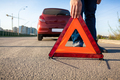 photo of man putting triangle warning sign on road - PhotoDune Item for Sale