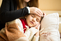 Closeup of caring mother holding head on sick daughter forehead - PhotoDune Item for Sale