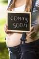 pregnant woman holding blackboard with text "Coming soon" - PhotoDune Item for Sale