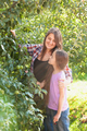 smiling mother and daughter posing at apple garden at sunny day - PhotoDune Item for Sale