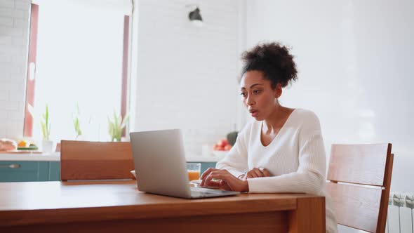 Serious African pregnant woman working on laptop