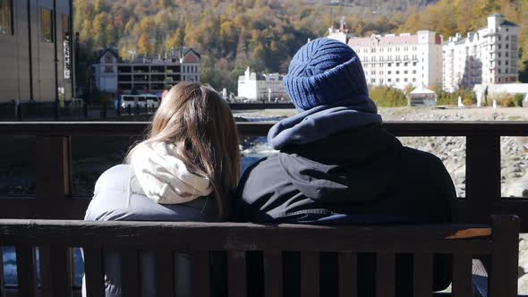 Happy Couple Sitting on a Wooden Bench Two Tourists on a Hike Vacation Travel Panoramic Beautiful