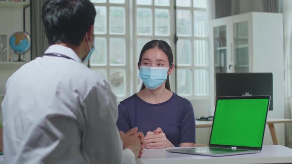 Asian Man Doctor Showing Green Screen Display On Laptop Computer During Consultation