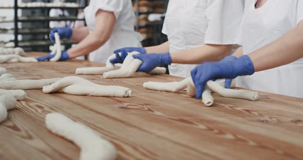 Professional Bakers Forming Pieces of Long Dough