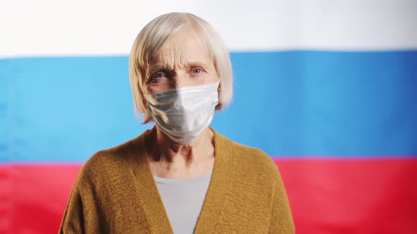 Senior Woman in Medical Mask Posing on Russian Flag
