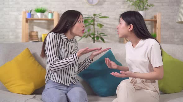 Two Young Asian Women Are Quarrel and Angry at Each Other Sitting in the Living Room