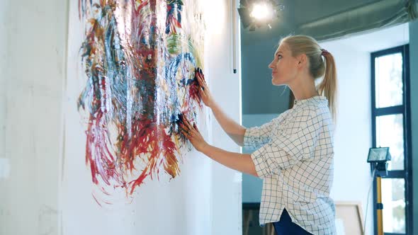 Joyful Lady is Using Her Bare Hands to Paint a Picture