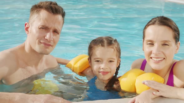 Young Family In Pool Water