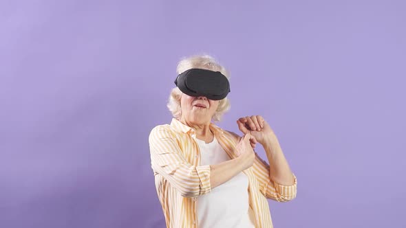 Slow Motion Old Grandmother Wearing Virtual Reality Headset and Having Fun Dancing in Vr Glasses.