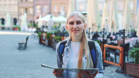 Zoom Shot of Trendy Young Woman with Map Smiling to the Camera