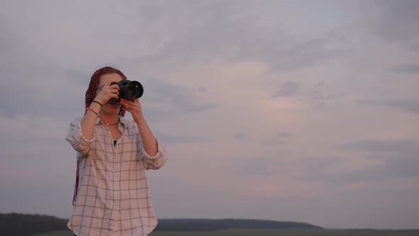 Caucasian Girl Taking Photos of a Sunset