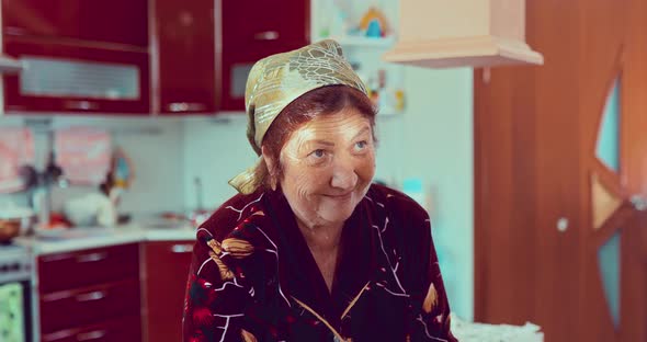 Pleasant Adult Woman is Standing in the Kitchen at Home