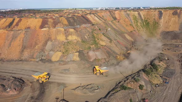 Two Large Mining Dump Truck Going to Meet Each Other on a Dusty Road