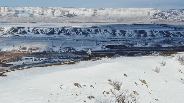 A Determined Athlete Trains on a Winter Morning on a Hilltop Against the Backdrop of a Snowcovered