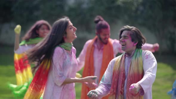 Indian couple dancing and wishing Happy Holi