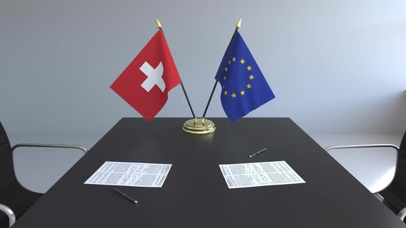 Flags of Switzerland and the European Union on the Table