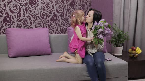 Little Daughter Child Congratulates Mother with Bouquet of Flowers. Slow Motion