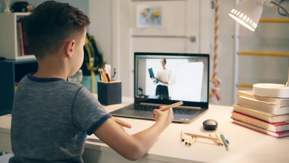 Little Kid Communicating with a Teacher From Home Using His Laptop