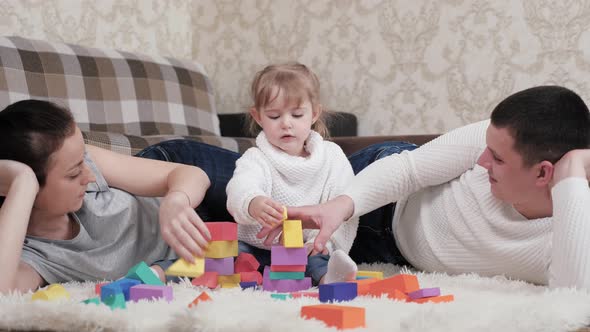 Dad Mother Kid Play Cubes in Nursery on Floor