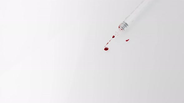 White Syringe with Blood Falls on the White Floor