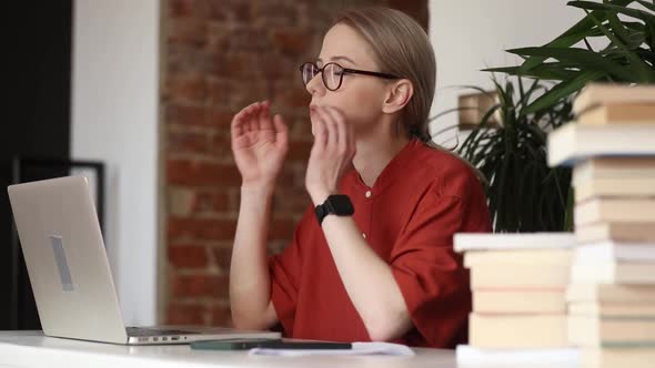 Tired woman working on her laptop in home office