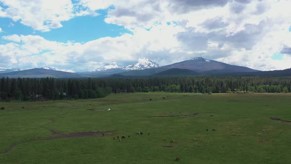 Aerial flying toward North and South Sisters mountains in rural Oregon.