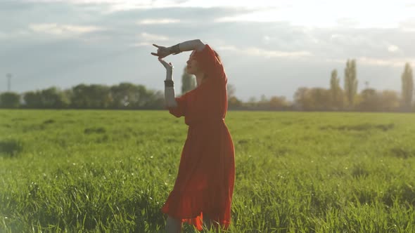 Beautiful Spanish Brunette Woman in Red Dress Dancing at Sunset in Wheat Field