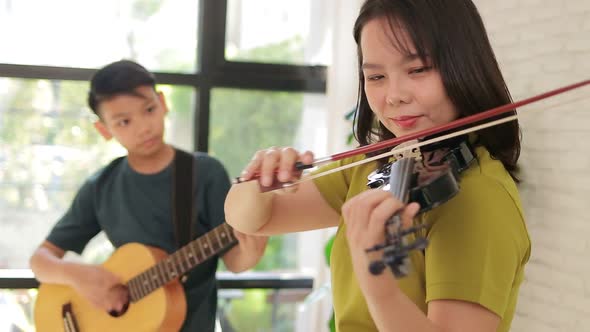 Asian mother and son live at home. The couple enjoyed playing music together.