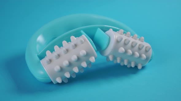 Anti-cellulite manual turquoise plastic massager with silicone rollers with pimples 