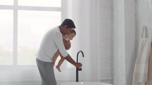 Father Drawing Bath for Toddler Girl