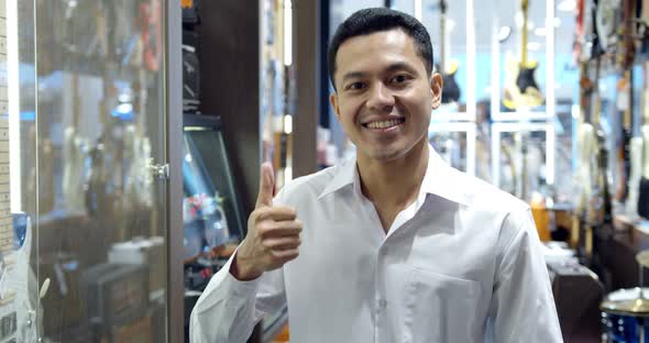 Portrait young smart muslim man at modern musical instrument store