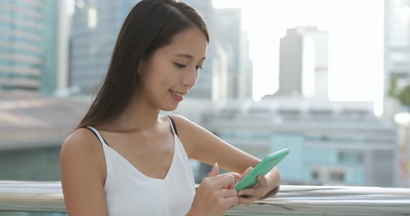 Woman typing on cellphone in the city