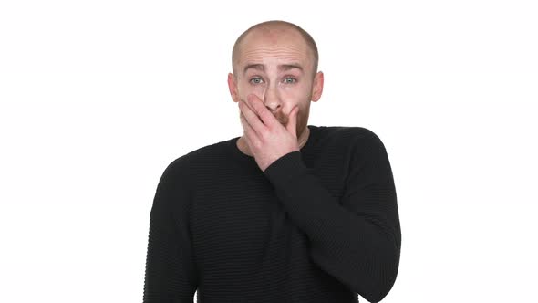 Portrait of Adult Bald Man Being Surprised and Shocked Covering Open Mouth with Hand Feeling Horror