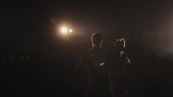 A Man Stands on the Stage and Looks Into the Audience