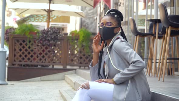 African American Girl in Medical Mask for the Prevention of Coronavirus and Looking at the Camera