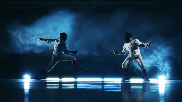 Slow Motion of Two Fencers Fighting in the Clouds of Smoke