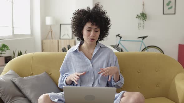 Young Adult Woman Having a Video Call on Laptop Computer at Home