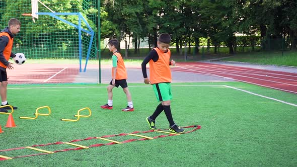 Boys in Football Uniforms which Doing Jogging Exercises on Soccer Ladder and Working