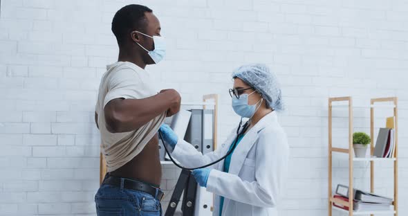 Health Examination. Medical Doctor Listening To Black Man Chest, Checking Lungs with Stethoscope