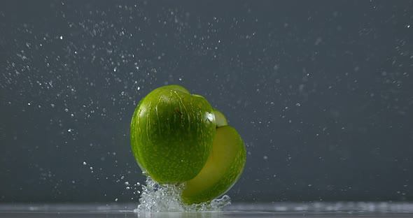 Granny Smith Apple, malus domestica, Fruit falling on Water against Black Background, Slow Motion 4K