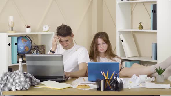 Young Exhausted Man and Woman Surfing Internet