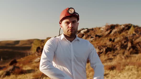 Man is Standing in an Office Shirt and with Helmet on Head Arms Crossed on Chest Looking Confidently