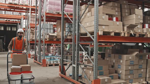 Worker Pushing Cart and Transporting Warehouse Items