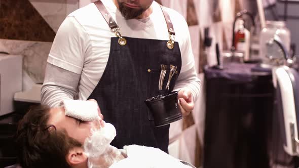 Man getting his beard shaved with shaving brush