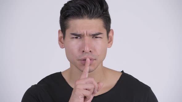 Face of Young Handsome Multi-ethnic Man with Finger on Lips