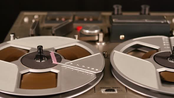 Vintage Reel to Reel tape recorder playing music close up of reel