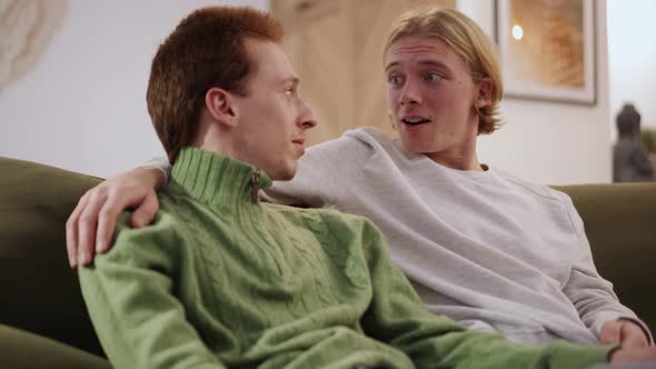 Blond gay couple talking at home